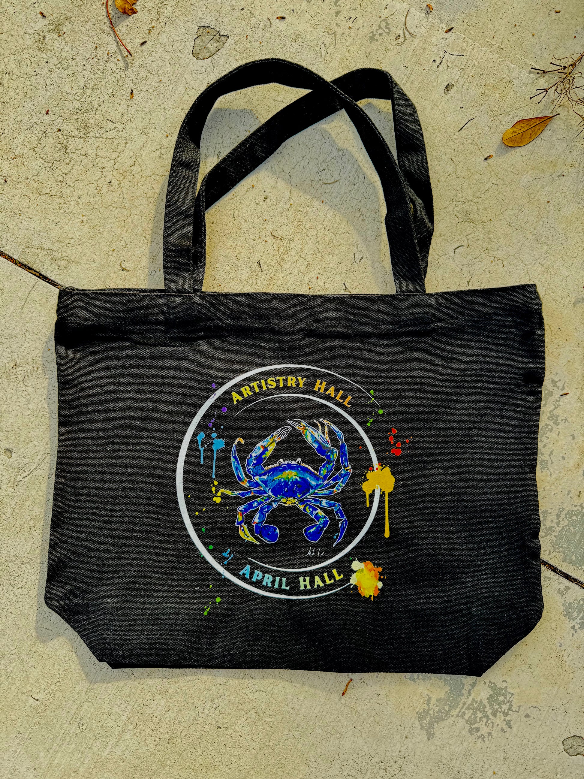 Black tote bag with Blue Crab design with the name "Artistry Hall" & artist "April Hall"