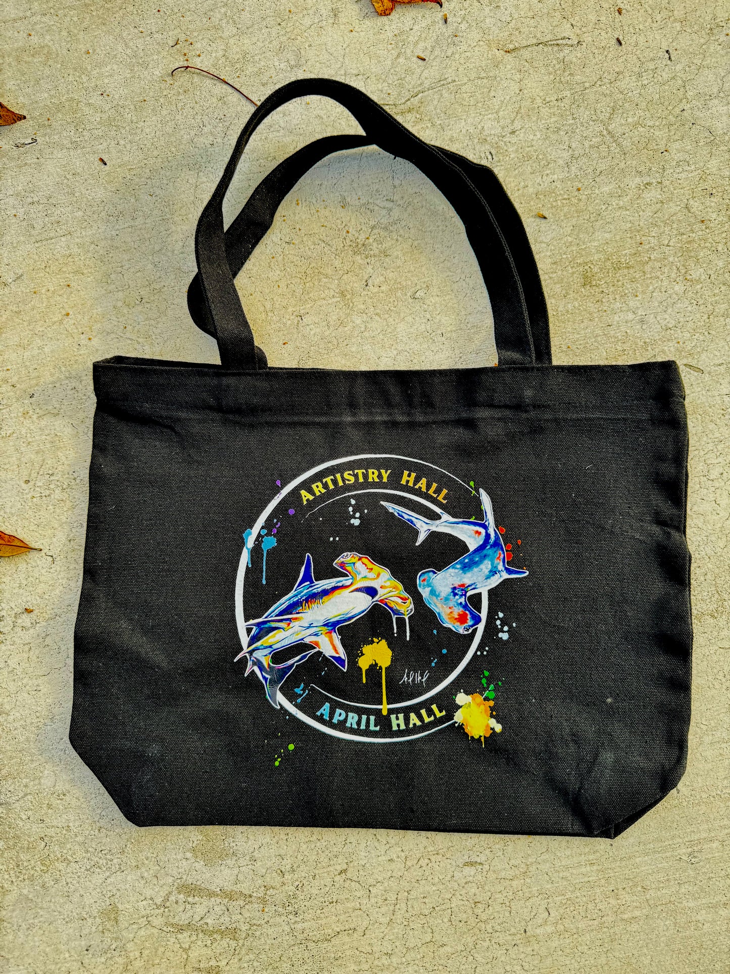 Black tote bag with Hammerhead Shark design with the name "Artistry Hall" & artist "April Hall"