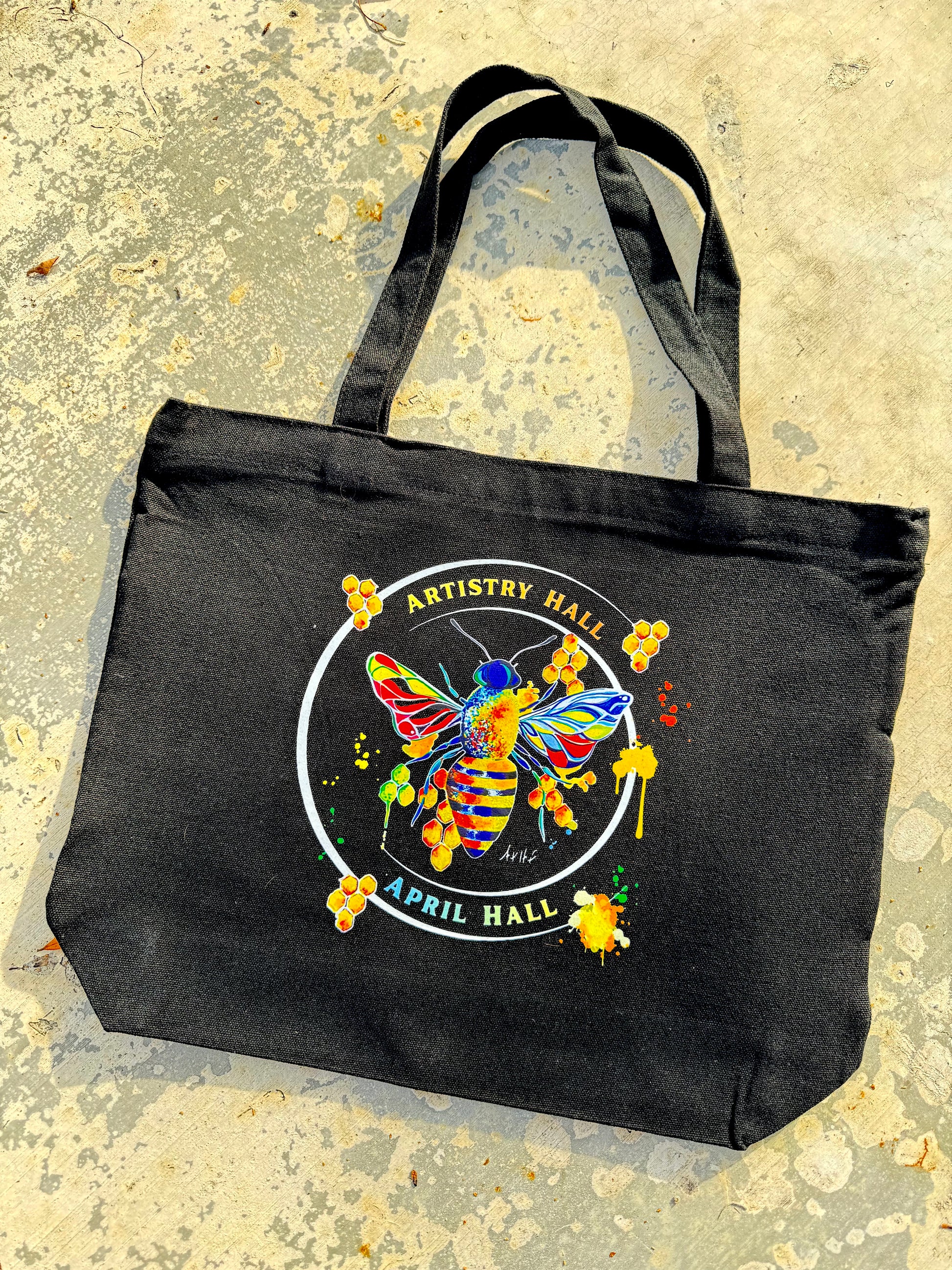 Black tote bag with Honey Bee design with the name "Artistry Hall" & artist "April Hall"