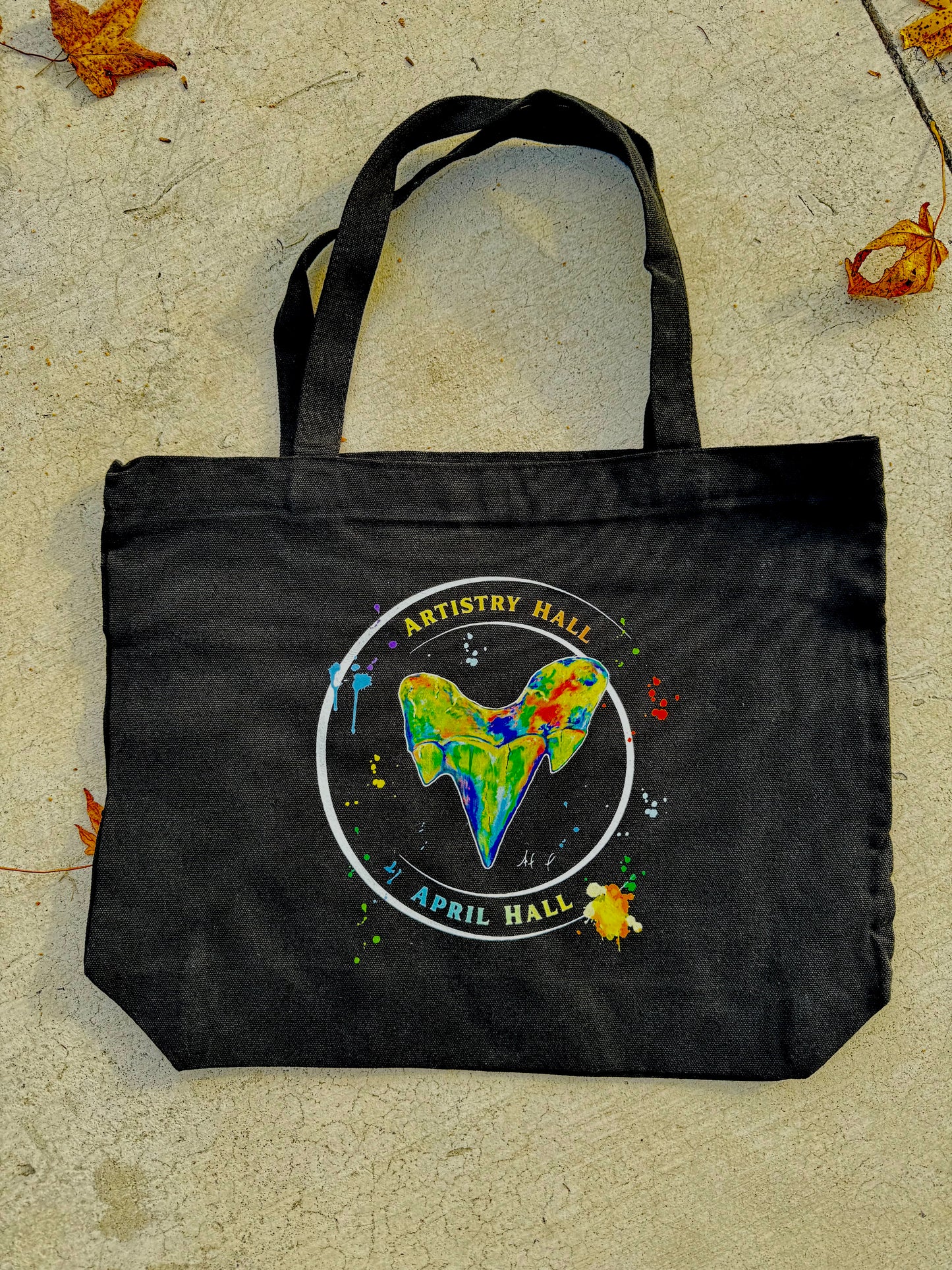 Black tote bag with Shark Tooth design with the name "Artistry Hall" & artist "April Hall"